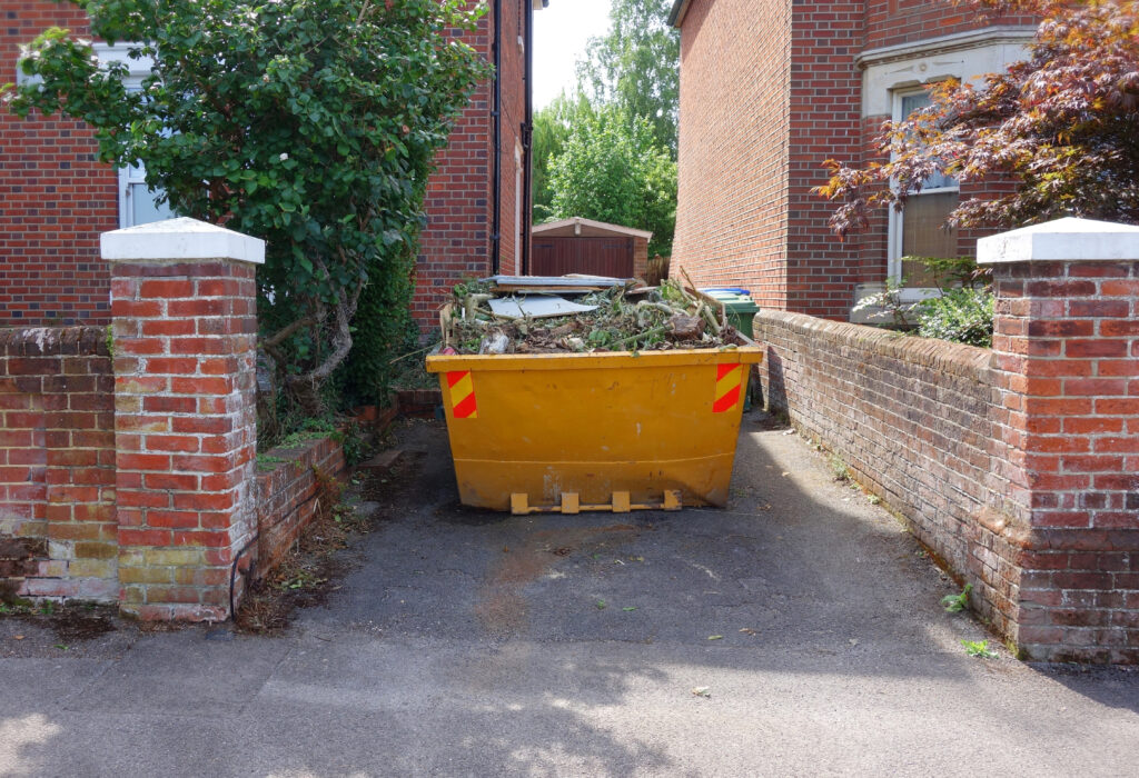 An image of a skip filled with garden waste.